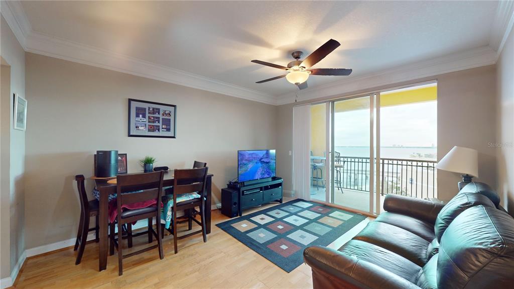 A living and dining area features hardwood floors, a ceiling fan, and a balcony view — 345 BAYSHORE BOULEVARD UNIT 1203, TAMPA, FL