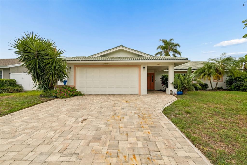 A single-story house with a paved driveway, a two-car garage, and a covered entryway — 1473 50TH AVENUE NE, ST PETERSBURG, FL