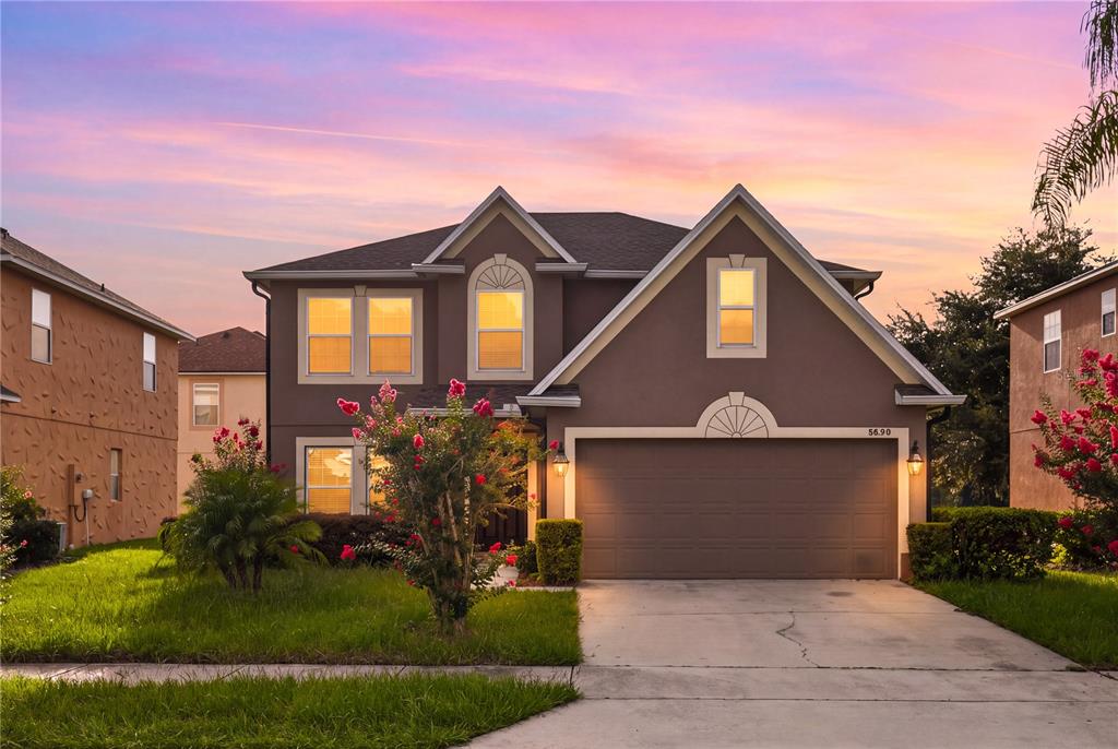 A two-story house with a brown exterior, a two-car garage, and a concrete driveway — 8830 ISLA BELLA DRIVE, ORLANDO, FL