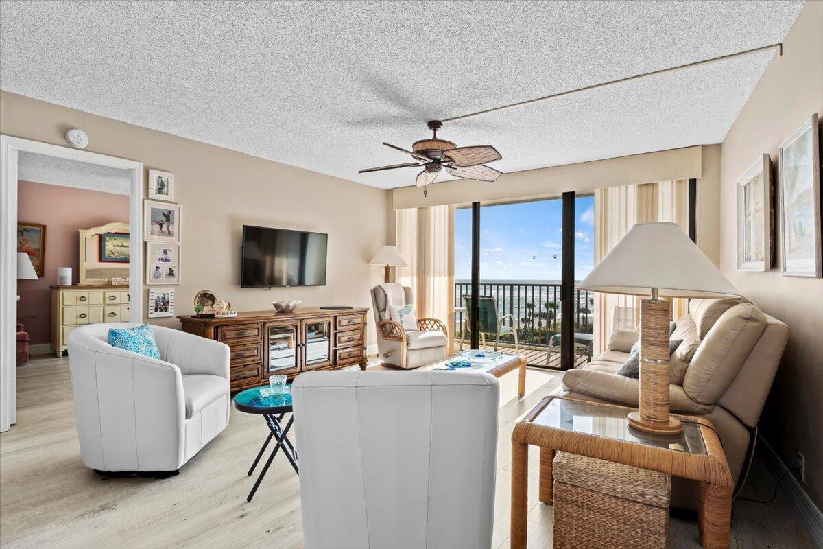 A living room features white leather chairs, a beige sofa, and a balcony with ocean views — 400 Ocean Trail Way # 504, Jupiter FL 33477, JUPITER, FL