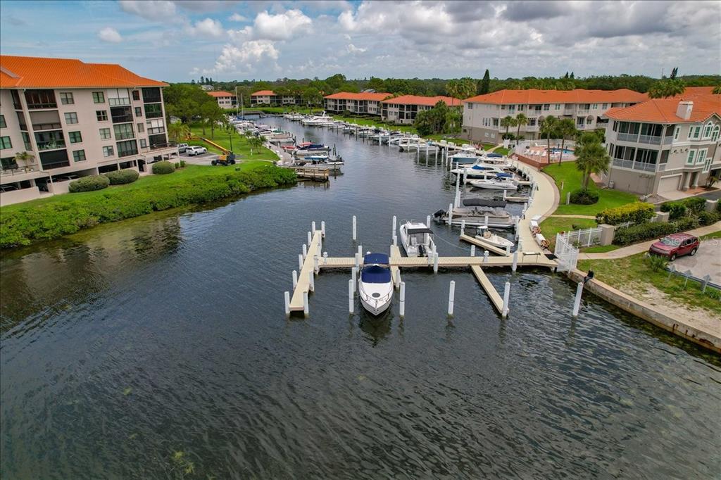 An aerial view shows a boat dock and marina surrounded by multi-story residential buildings — 401 MARINER DRIVE UNIT 401, TARPON SPRINGS, FL