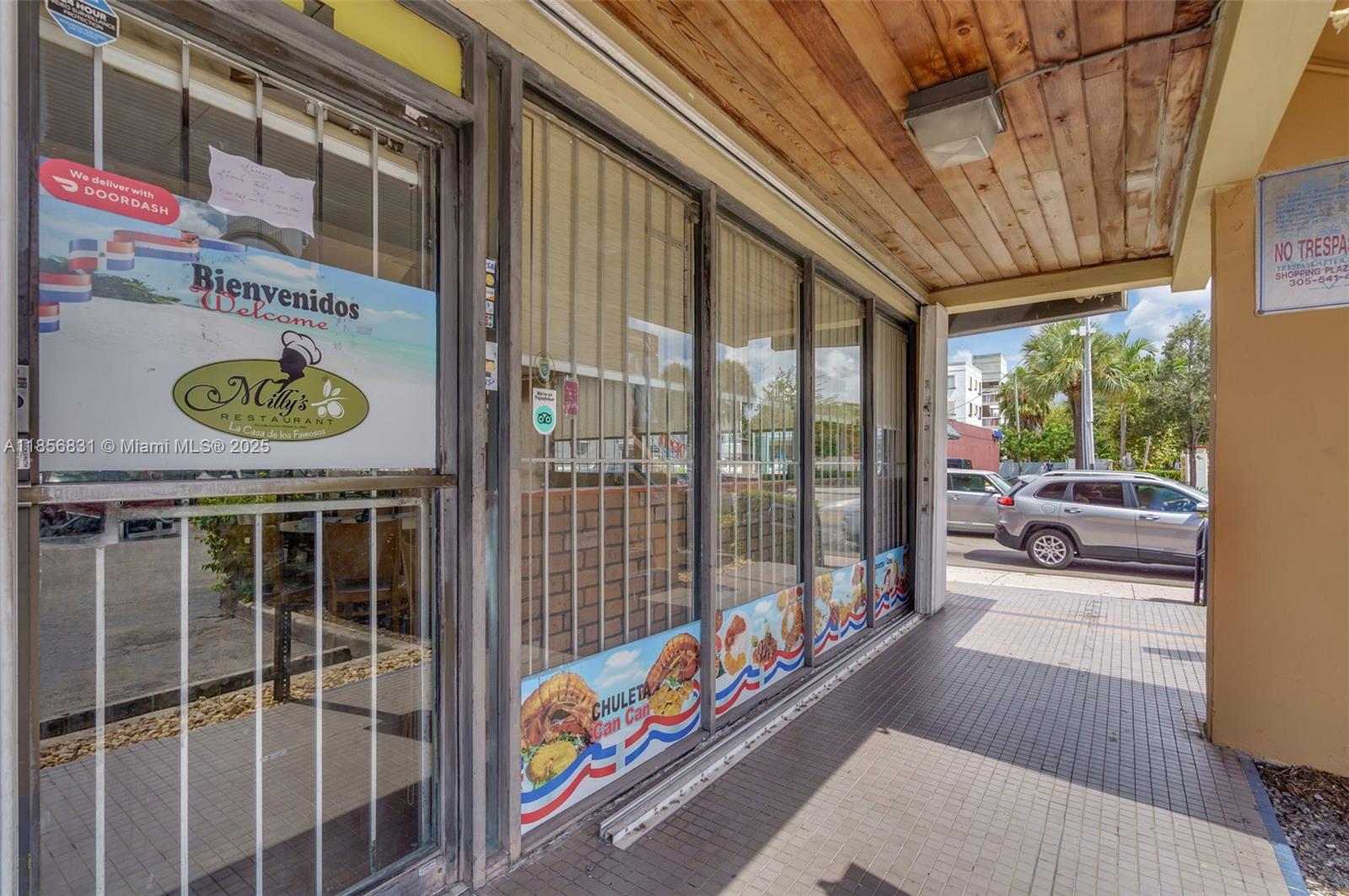 The exterior of a restaurant storefront features glass windows, metal security bars, and signage — 2742 SW 8th St, Miami FL 33135, MIAMI, FL