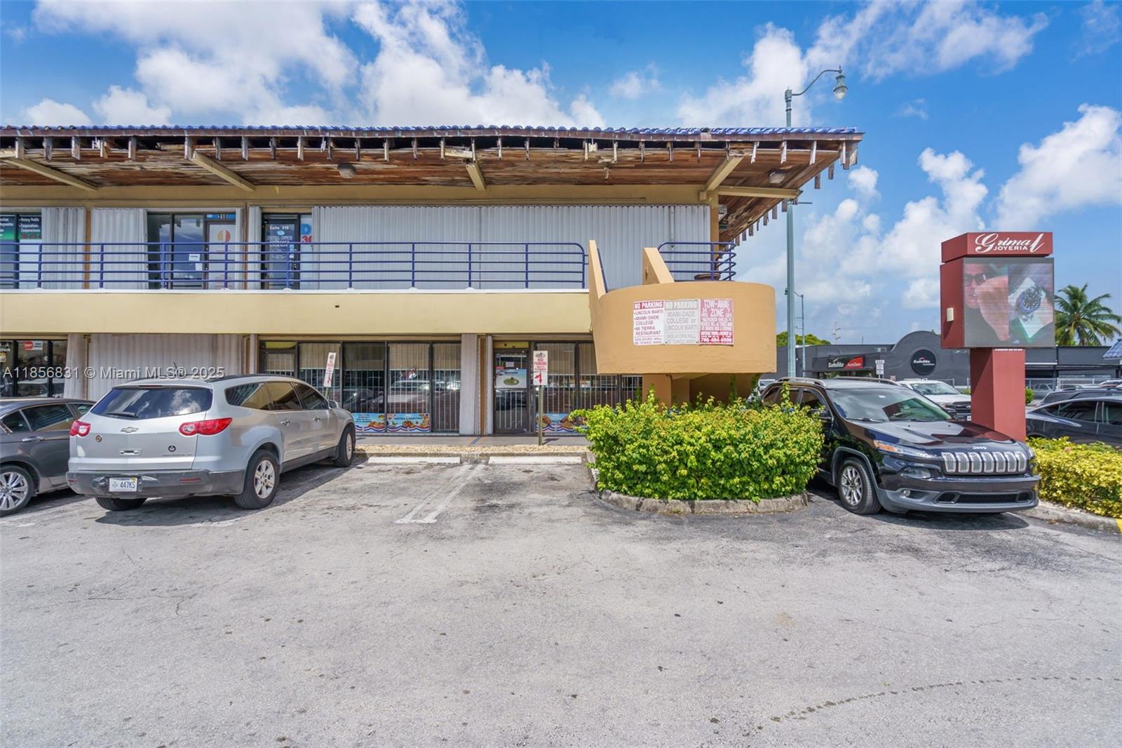 A two-story commercial building with a parking lot and a prominent signage pillar — 2742 SW 8th St, Miami FL 33135, MIAMI, FL