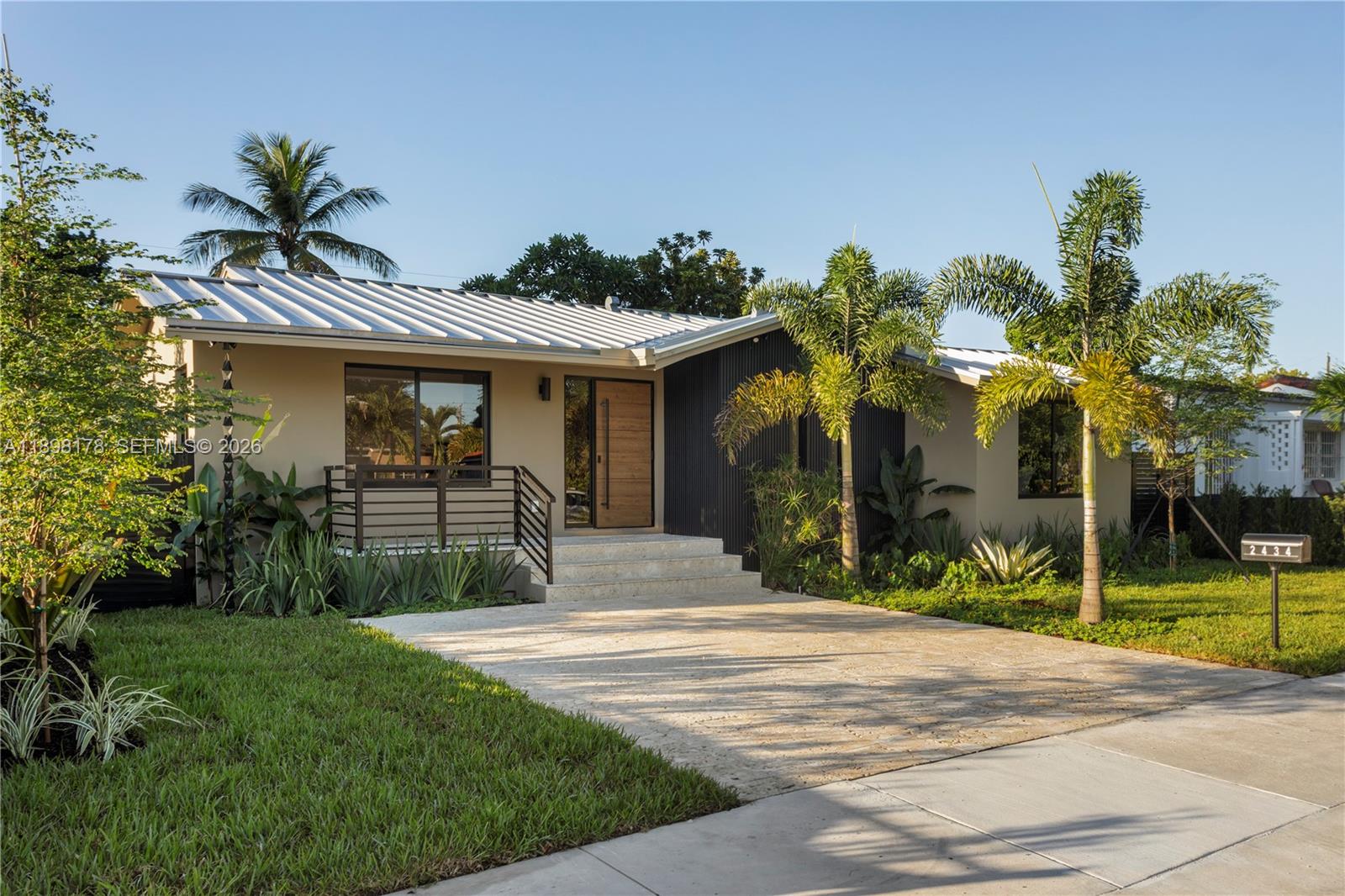 A single-story house features a metal roof, a wood front door, and a paved driveway — 2434 SW 19th St, Miami FL 33145, MIAMI, FL