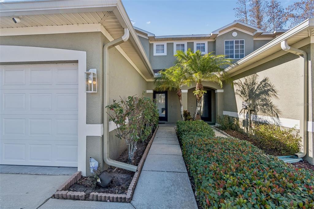 A walkway leads to the front entrance of a two-story home with a garage — 8809 CASABLANCA WAY, TAMPA, FL