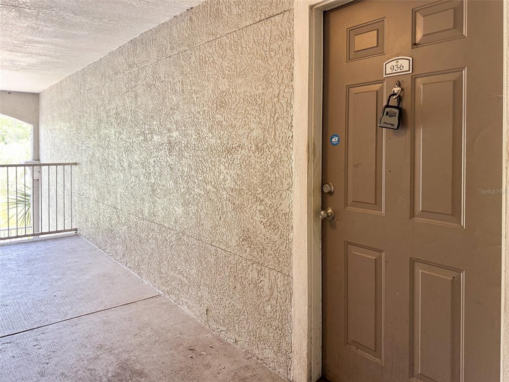 A tan exterior door with a lockbox and unit number 936 on a concrete walkway — 3373 S KIRKMAN ROAD UNIT 936, ORLANDO, FL