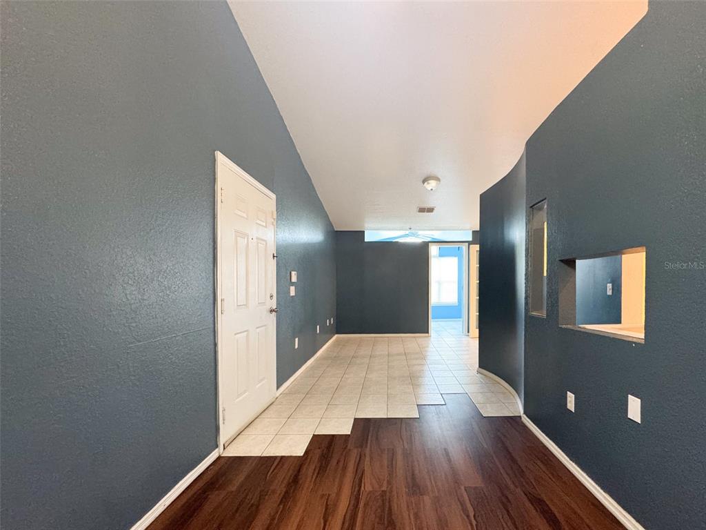 An entryway features dark blue walls, a white door, and a mix of tile and wood flooring — 3373 S KIRKMAN ROAD UNIT 936, ORLANDO, FL
