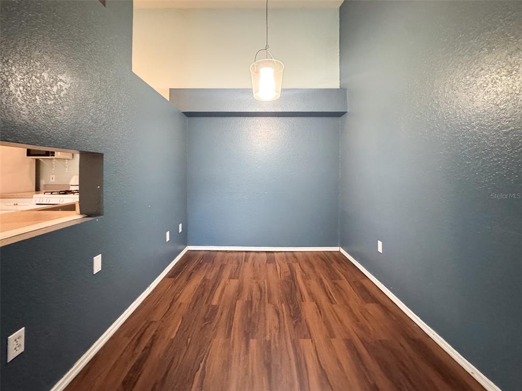 A dining area features dark blue walls, wood-look flooring, and a single pendant light fixture — 3373 S KIRKMAN ROAD UNIT 936, ORLANDO, FL