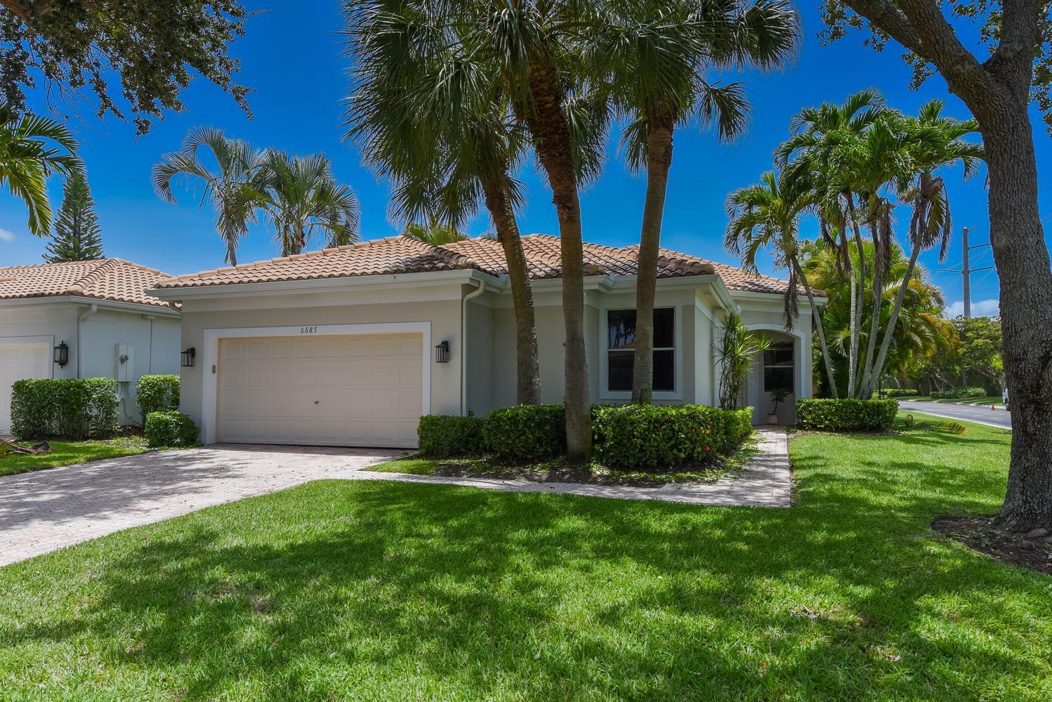 A single-story house with a beige exterior, a two-car garage, and palm trees in front — 6685 NW 24th Terrace, Boca Raton FL 33496, BOCA RATON, FL