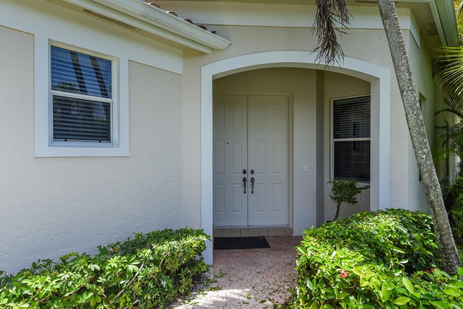 The exterior of a house features a double front door under an arched entryway — 6685 NW 24th Terrace, Boca Raton FL 33496, BOCA RATON, FL