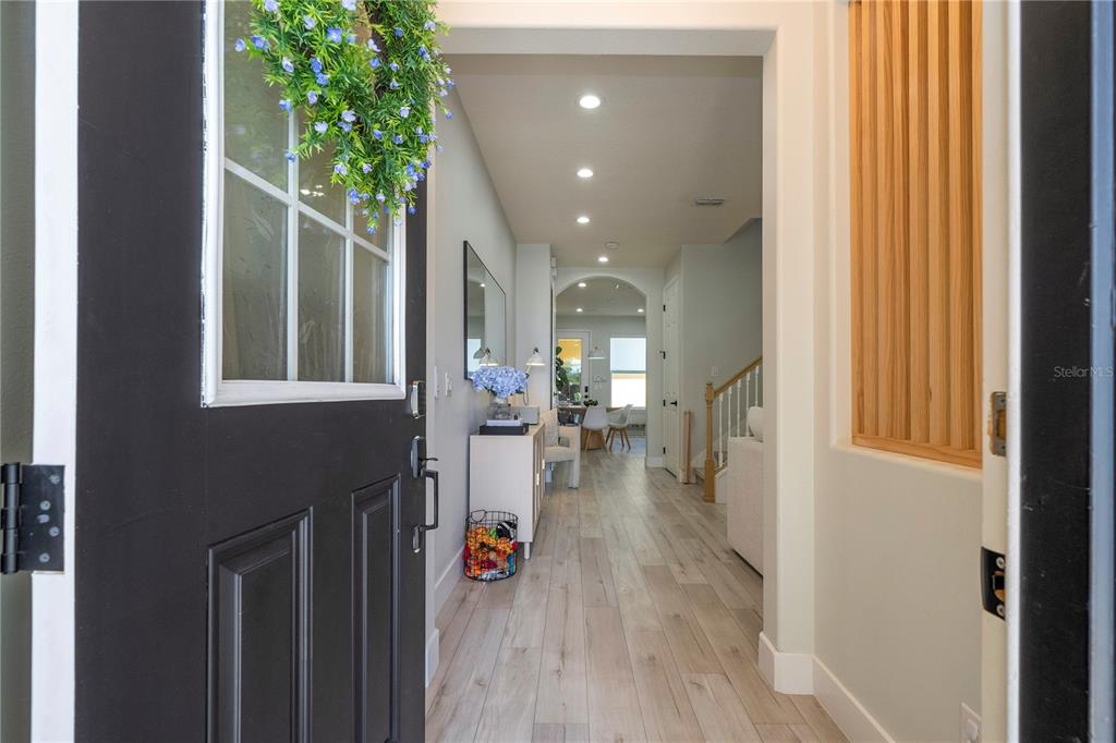 A view from an open front door into a hallway with light wood-look flooring — 11861 VERMILLION AVENUE, WINDERMERE, FL