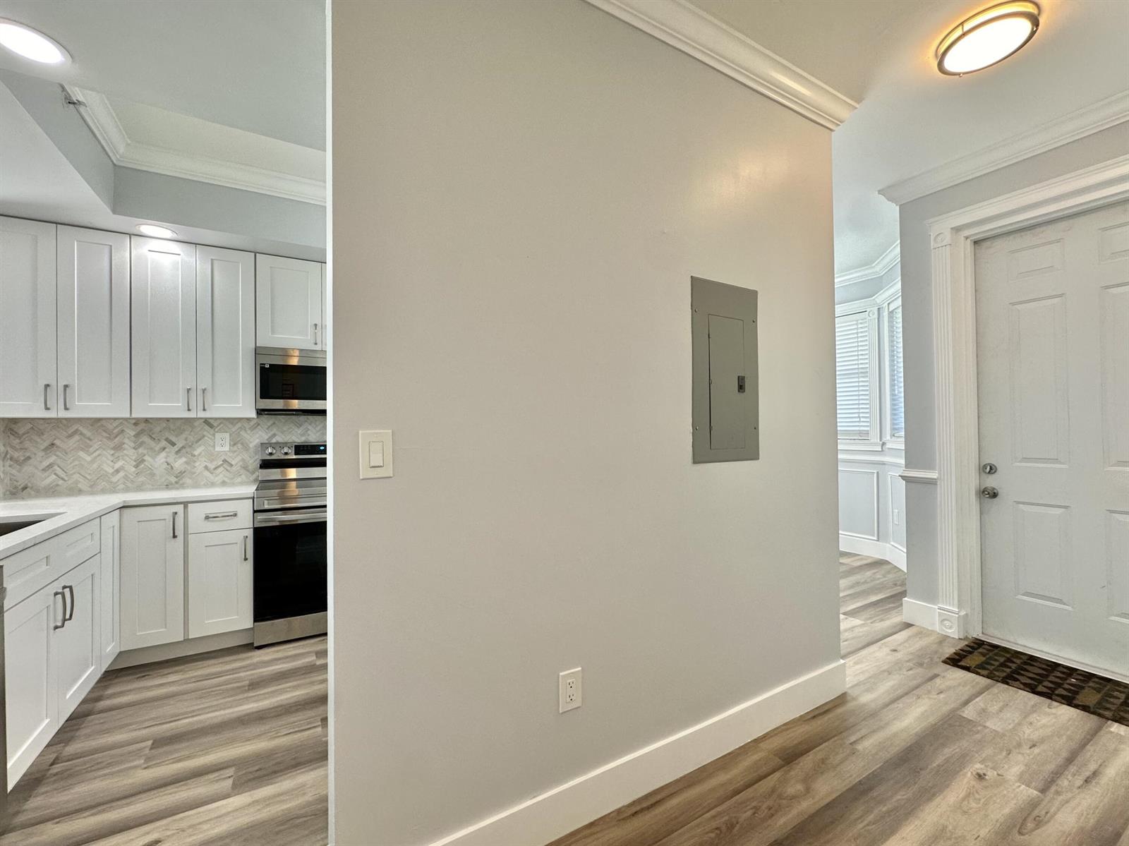 A kitchen with white cabinets and a gray electrical panel on the adjacent wall — 27 Royal Palm Way # 406, Boca Raton FL 33432, BOCA RATON, FL