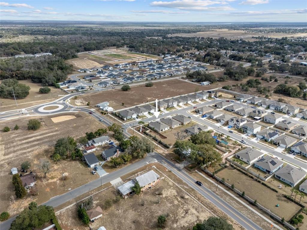An aerial view shows a suburban neighborhood with a white arrow pointing to a house — 2006 DOE RUN DRIVE, DAVENPORT, FL