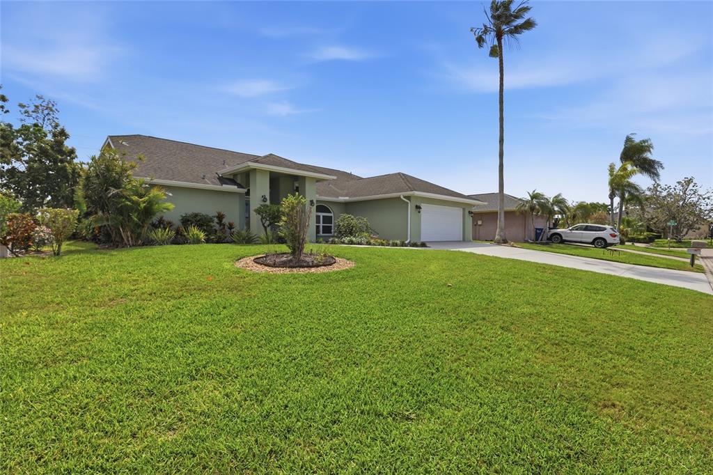 A single-story house with a green exterior, a two-car garage, and a palm tree — 5207 86TH STREET COURT W, BRADENTON, FL