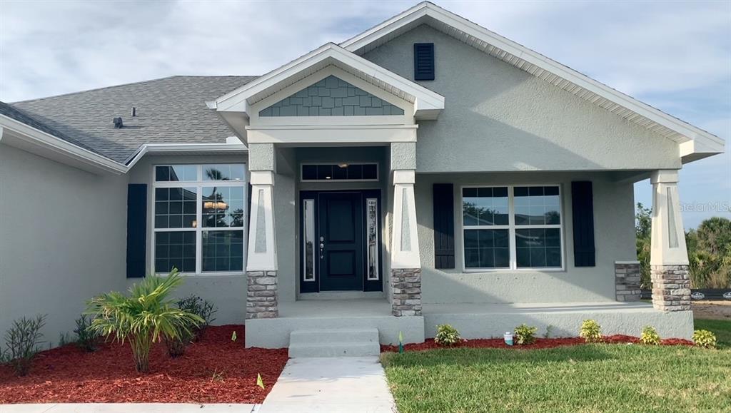 A single-story house exterior features a covered porch, stone-based columns, and a dark front door — 13236 PACE CIRCLE, PORT CHARLOTTE, FL