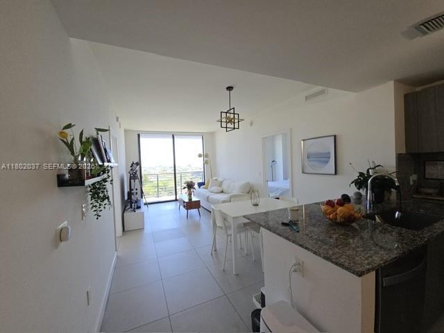 An open-concept living area features a kitchen with granite countertops and a bright, modern living room — 5350 NW 84th Ave # 1207, Doral FL 33166, DORAL, FL
