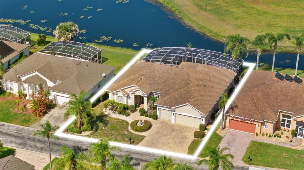 An aerial view of a suburban house with a screened pool enclosure and a lake — 622 GOLF COURSE PARKWAY, DAVENPORT, FL