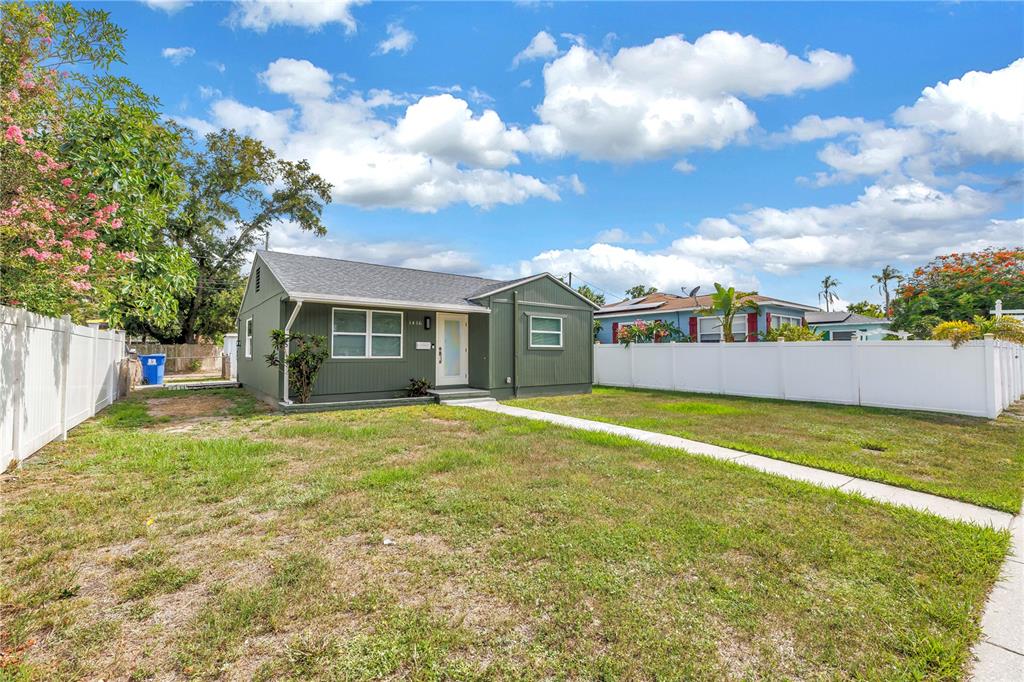 A green, single-story house with a white front door sits on a grassy lot — 1416 38TH AVENUE N, ST PETERSBURG, FL