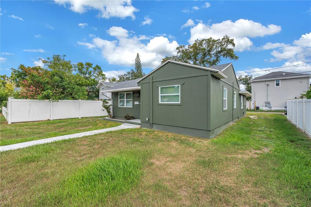 A single-story house with olive green siding and white trim sits on a grassy lot — 1416 38TH AVENUE N, ST PETERSBURG, FL