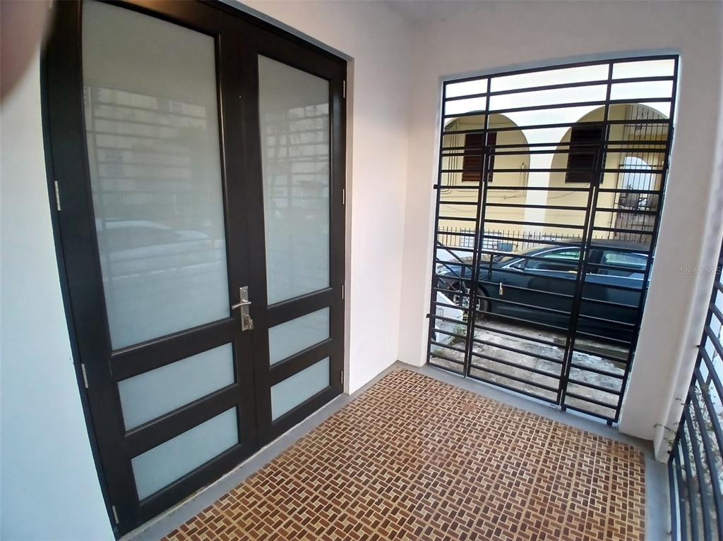 An entryway features a double glass door and a large window with black security bars — 1002 MADRID STREET, SAN JUAN, PR