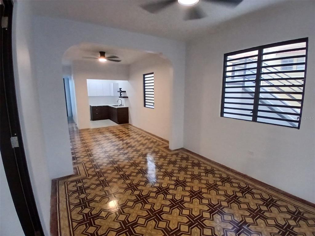 An interior view of a room with patterned tile flooring, white walls, and a kitchen area — 1002 MADRID STREET, SAN JUAN, PR