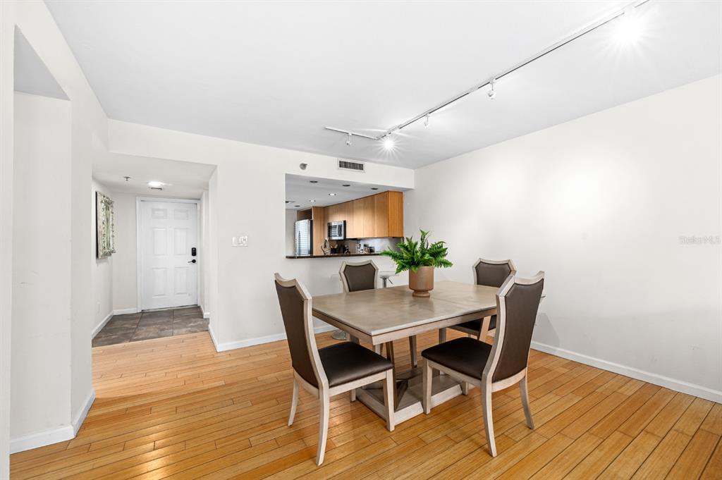 A dining area with a wooden table, four chairs, and hardwood floors near a kitchen — 201 W LAUREL STREET UNIT 310, TAMPA, FL