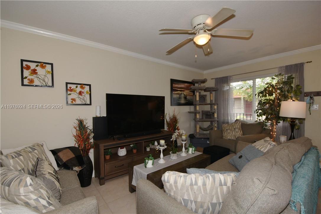 A living room features a television on a wooden stand, two sofas, and a ceiling fan — 3050 NE 5th Ter # 8, Wilton Manors FL 33334, WILTON MANORS, FL