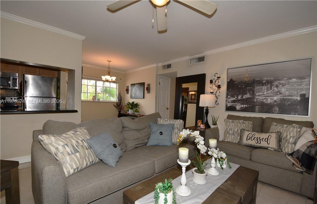 A living room features gray sofas, a wooden coffee table, and a large wall print — 3050 NE 5th Ter # 8, Wilton Manors FL 33334, WILTON MANORS, FL