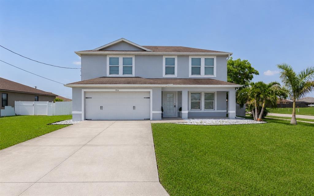 A two-story house with a gray exterior, a two-car garage, and a concrete driveway — 1916 SW 12TH TERRACE, CAPE CORAL, FL