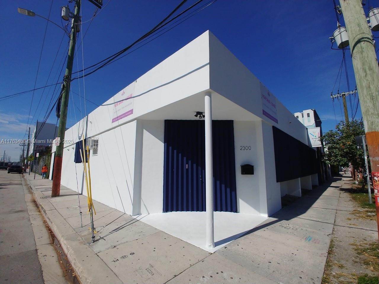 A white corner commercial building features a blue corrugated metal entrance and a support column — 2300 N Miami Ave, Miami FL 33127, MIAMI, FL