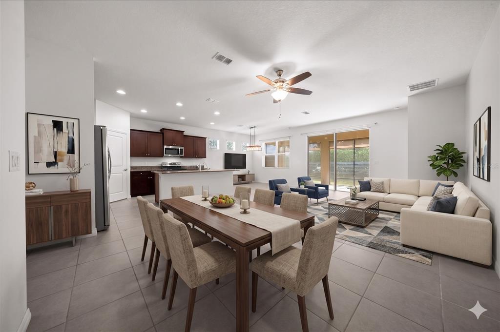 An open-concept living and dining area features tile floors, a kitchen island, and neutral furniture — 9139 SW 60TH COURT ROAD, OCALA, FL
