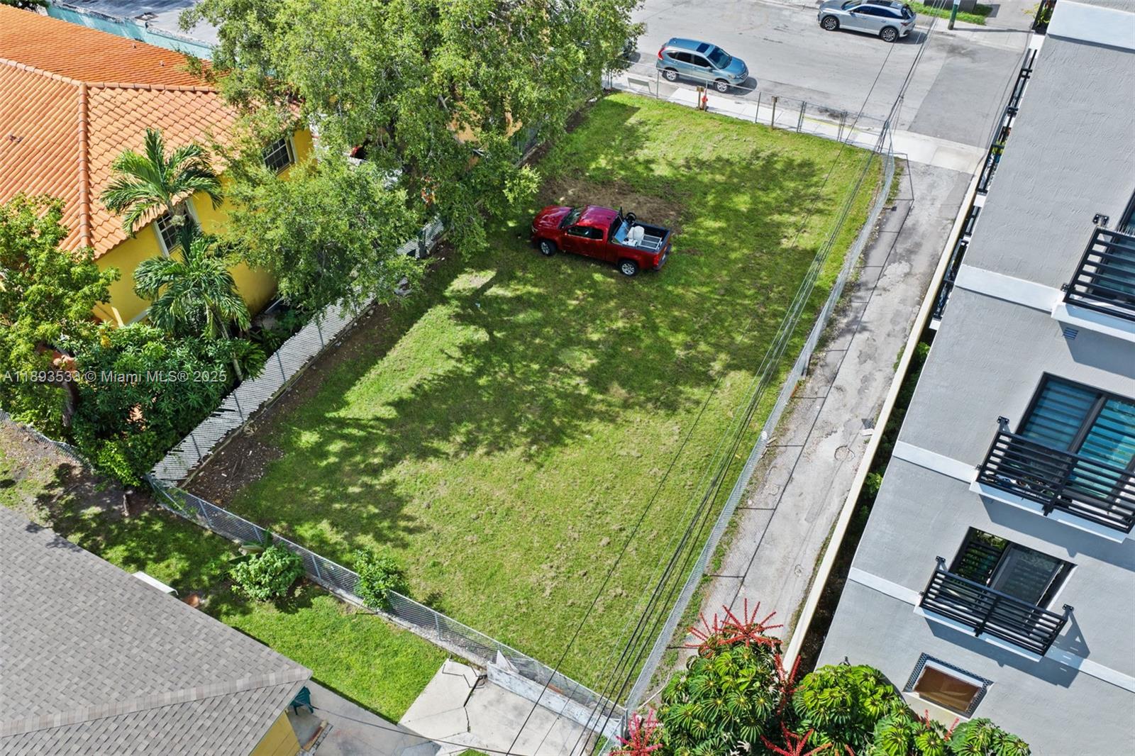 An aerial view shows a vacant rectangular grass lot with a red pickup truck parked inside — 129 SW 21st Ave, Miami FL 33135, MIAMI, FL
