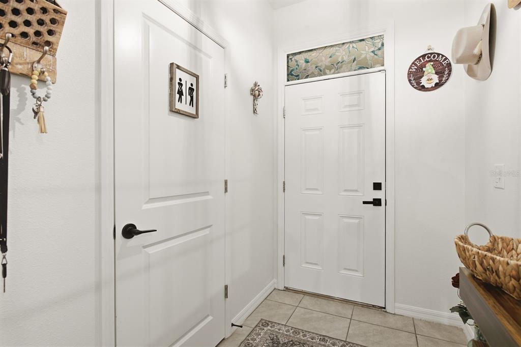 A white interior door and a front door with a transom window in an entryway — 16119 GLOWING GROVE AVENUE, ODESSA, FL