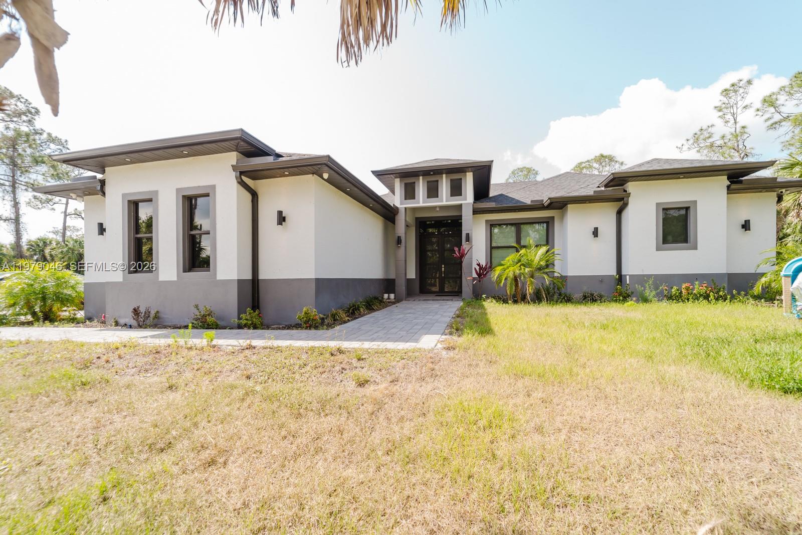 A single-story house with a white and gray exterior, a paved walkway, and a front entrance — 398 35th Ave NW, Naples FL 34120, NAPLES, FL