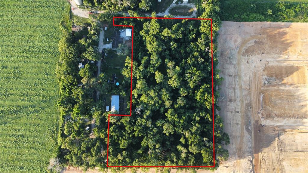 An aerial view shows a wooded lot outlined in red next to a construction site — SKYLINE DRIVE, DADE CITY, FL