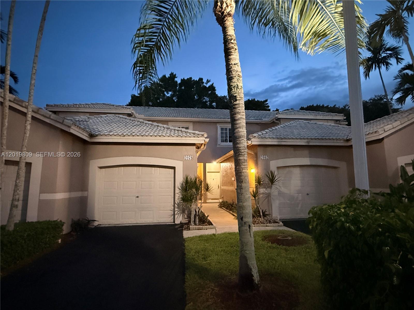 A two-story residential building features two garage doors, a central entryway, and a palm tree — 2078 Madeira Dr # 0, Weston FL 33327, WESTON, FL