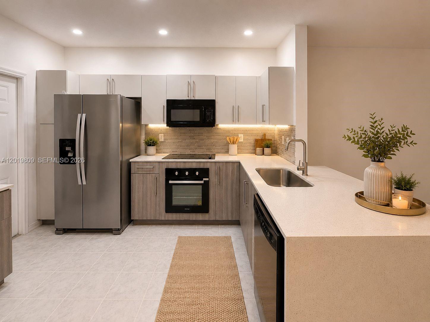 A modern kitchen features stainless steel appliances, light wood lower cabinets, and white upper cabinets — 2078 Madeira Dr # 0, Weston FL 33327, WESTON, FL