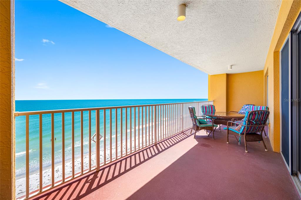 A balcony with a metal railing overlooks the ocean and features outdoor patio furniture — 16550 GULF BOULEVARD UNIT 645, NORTH REDINGTON BEACH, FL