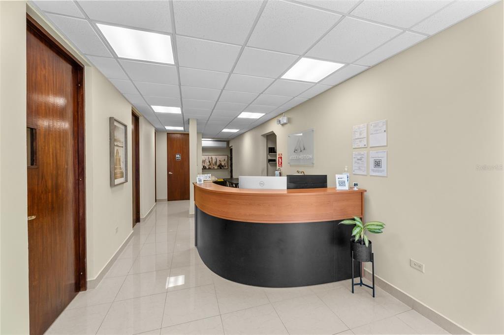 A reception area features a curved wooden desk, tile flooring, and a drop ceiling — 152 C. NÚÑEZ ROMERO UNIT 152, CAYEY, PR