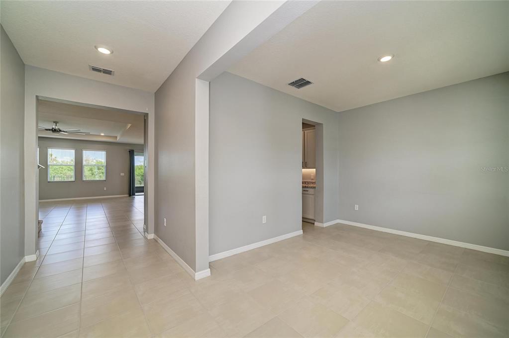 An entryway features light-colored tile flooring, gray walls, two windows, and a white front door — 2230 MARSH HARBOUR LOOP, BRADENTON, FL
