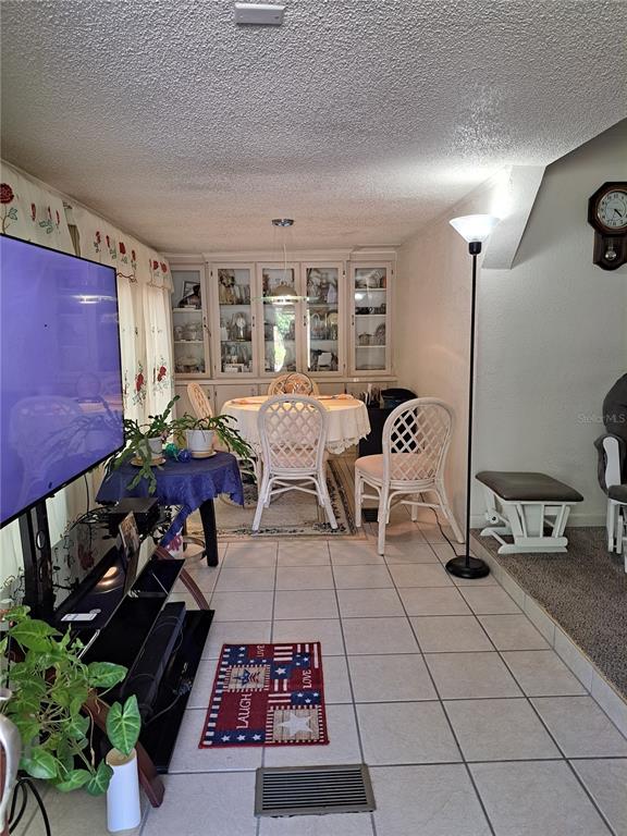 A dining area with a white table and chairs sits adjacent to a living room — 119 DAISY AVENUE, AUBURNDALE, FL