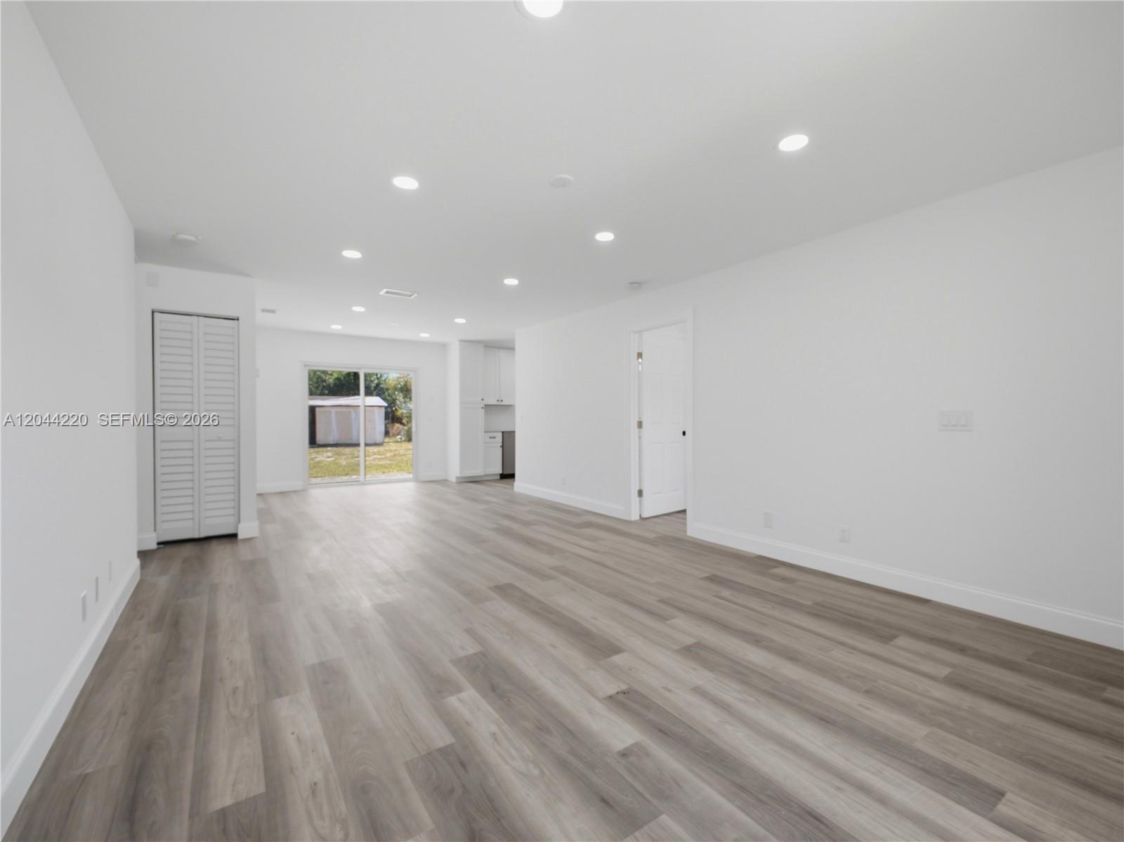 A bright, open-concept living area features white walls, recessed lighting, and light wood-look flooring — 1229 18th Ave N, Lake Worth FL 33460, LAKE WORTH, FL