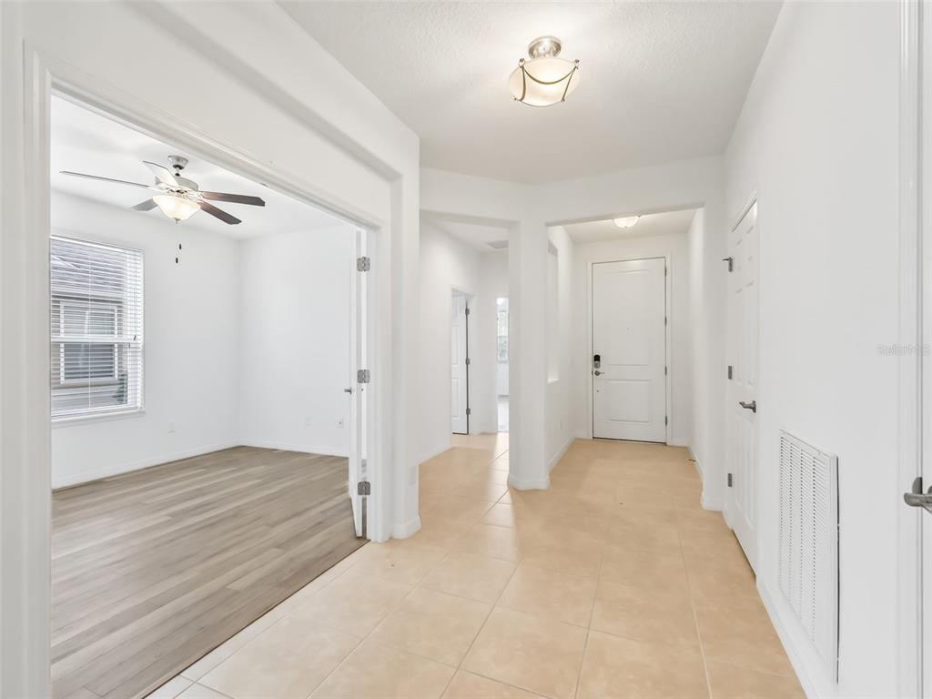 An entryway with tile flooring leads to a room with wood-look floors and French doors — 4976 NW 35TH LANE ROAD, OCALA, FL