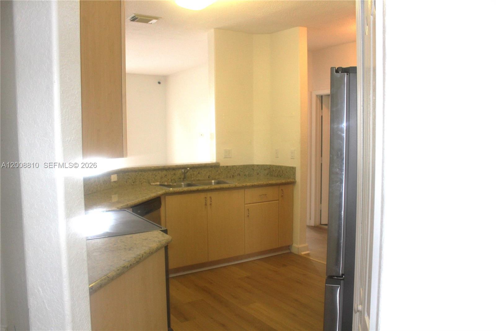 A kitchen features light wood cabinets, granite countertops, and stainless steel appliances — 11375 NW 77th Ln # 11375, Doral FL 33178, DORAL, FL