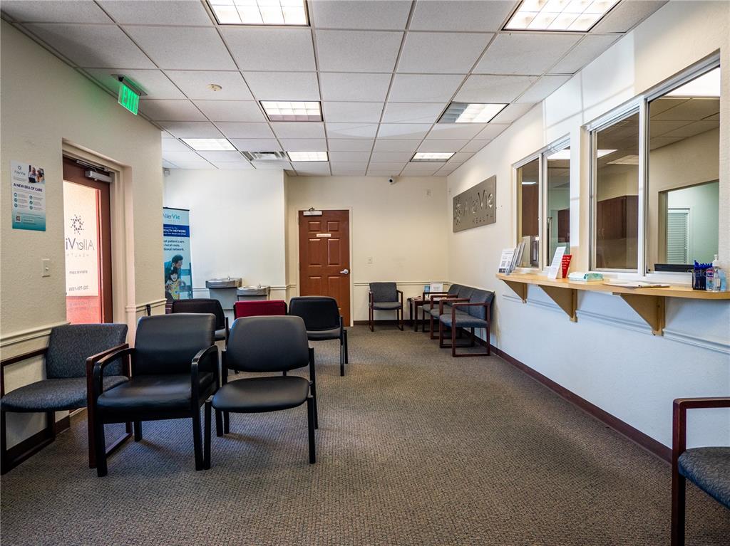 A waiting room with rows of chairs, a reception window, and a drop ceiling — 309 LAGRANDE BOULEVARD, LADY LAKE, FL