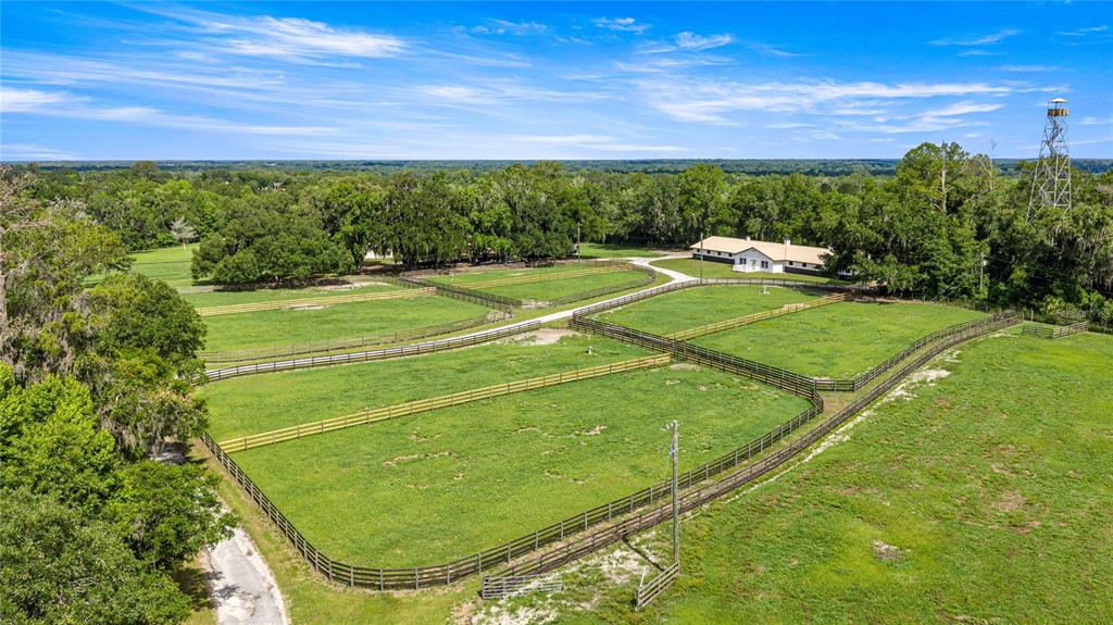 An aerial view shows a rural property with fenced pastures, a barn, and a tall tower — 12670 N US HIGHWAY 27, OCALA, FL