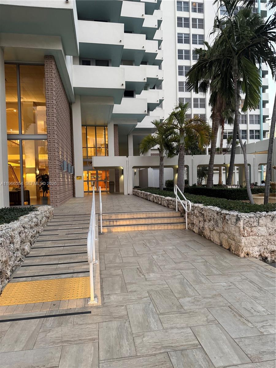 An exterior view shows a building entrance with a ramp, stairs, and palm trees — 2899 Collins Ave # 936, Miami Beach FL 33140, MIAMI BEACH, FL