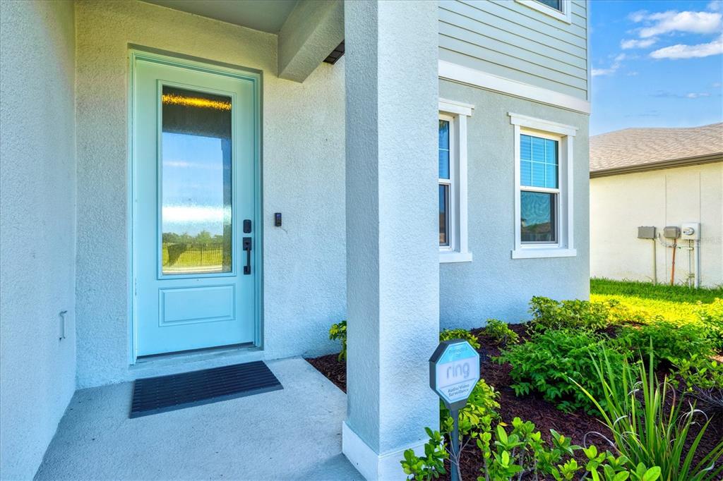 A light blue front door stands at the entrance of a house with stucco siding — 506 SUN CHASER DRIVE, NOKOMIS, FL