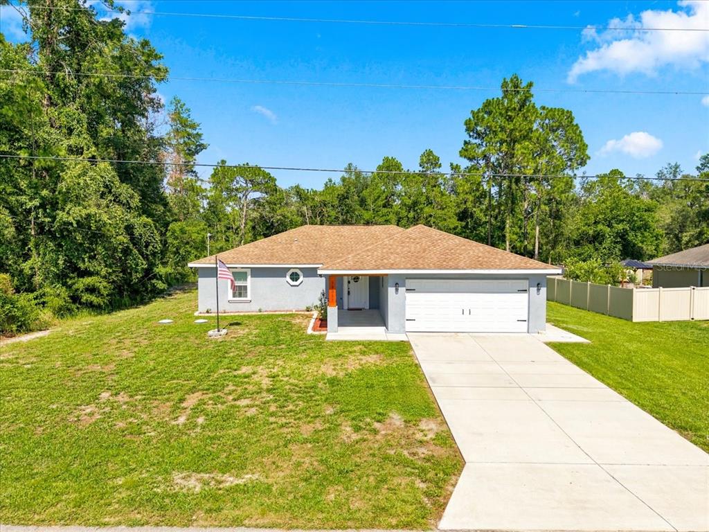 A single-story gray house with a two-car garage and a concrete driveway — 12327 MILLINGTON AVENUE, WEEKI WACHEE, FL