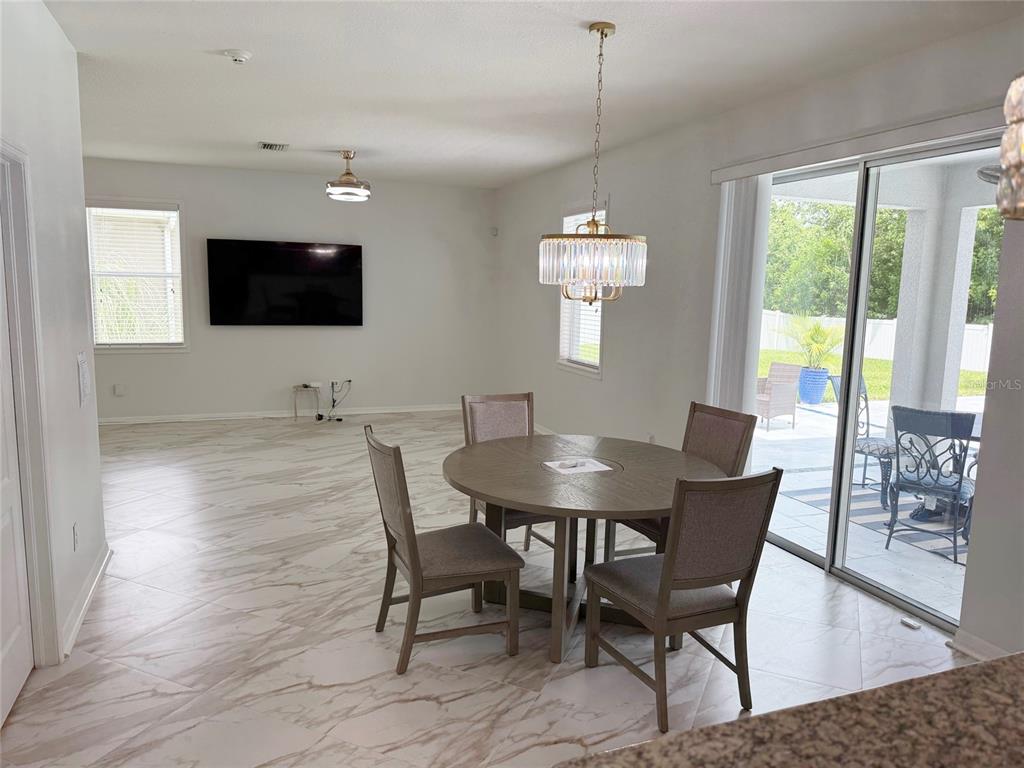 A dining area with a round table and chairs sits on marble-look tile flooring — 12236 FAIRLAWN DRIVE, RIVERVIEW, FL